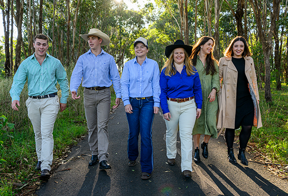 The six RAS Rural Scholarship finalists walking along a tree-lined path, smiling and talking.