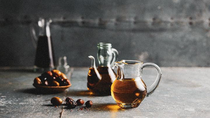 Glass jugs of olive oil with olives on display at the Sydney Royal Fine Food Show's Oil & Olives Competition.