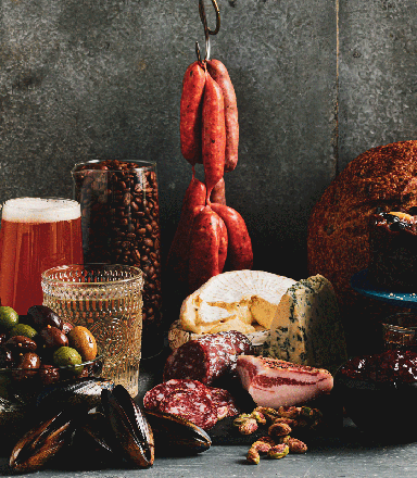 Charcuterie display of gourmet food and drinks including wine, cheese, coffee, olives and bread for the Annual President's Medal Competition.